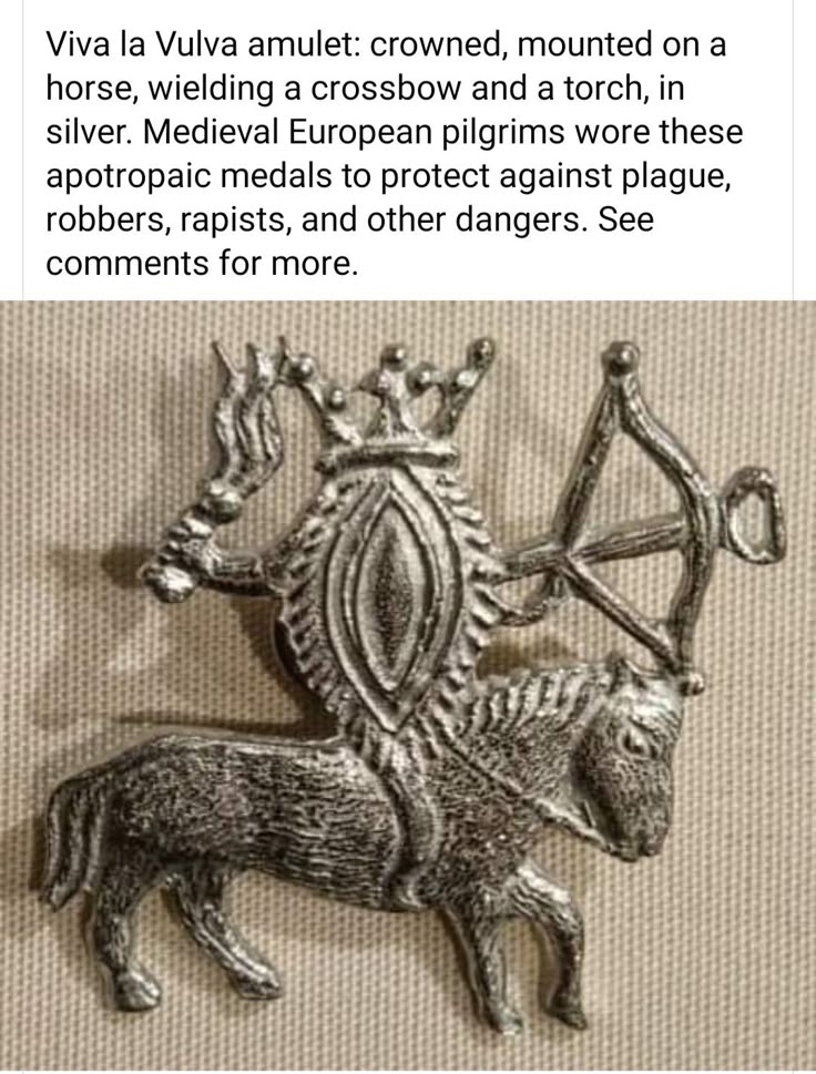 the image shows a silver amulet depicting a vulva crowned and mounted on a horse. the vulva figure is also wielding a crossbow and a torch. the amulet is described as a medieval european apotropaic medal worn to protect against plague, robbers, rapists, and other dangers.