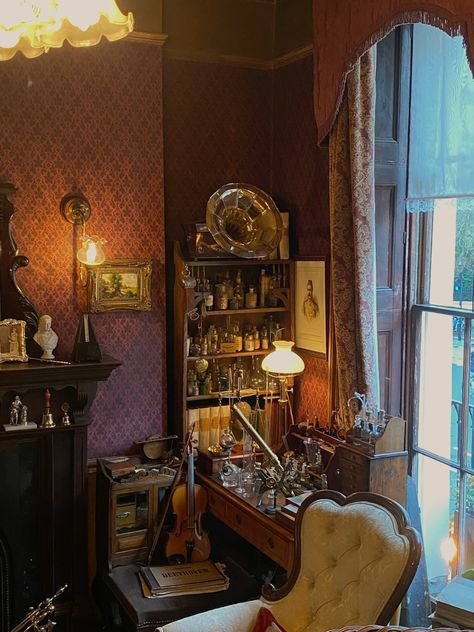 this image captures a vintagestyle room filled with antique furniture and intriguing objects. a gramophone sits atop a shelf filled with various bottles and vials. a violin rests on a case in the foreground, hinting at a love for music.  the warm, artificial light from a nearby lamp casts a cozy glow over the scene, illuminating the rich, dark hues of the furniture and wallpaper. the overall ambiance evokes a sense of history and mystery.