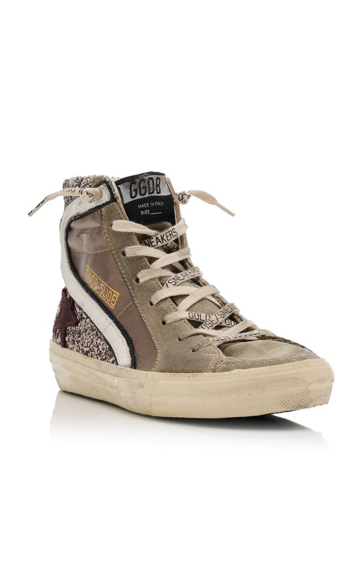 the image shows a single pair of golden goose deluxe brand hightop sneakers for women.  the sneakers are primarily beige suede with a mauvetoned glitter panel on the side and are accented with a white stripe and goldcolored lettering on the side. the shoes feature a white rubber sole that appears slightly worn, adding to the vintage aesthetic. the laces are tied and the sneakers are shown from a slightly elevated angle, capturing a side profile view. the background is plain white, allowing the shoes to be the main focus of the image.