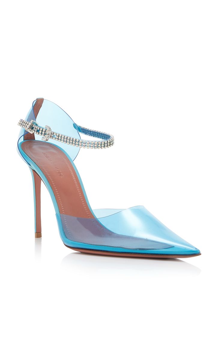 a pair of aquazzura light blue transparent pvc pumps with a pointed toe and a crystal embellished ankle strap. the heels are stiletto style and the shoes are shown on a white background.