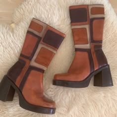a pair of brown vintage platform boots on a fuzzy background. both boots feature a high heel and a geometric pattern on the leather.