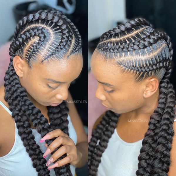 a black woman with long thick black braids, styled with two braids on the top of her head, and two braids coming down on either side of her face.