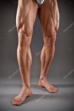 the image showcases the lower body of a muscular man with defined leg muscles.  he is standing against a plain gray background, highlighting the details of his physique. his legs, particularly his quadriceps and calves, exhibit significant muscular development, suggesting dedication to weight training and fitness.  he is wearing white underwear. the lighting is soft and even, emphasizing the contours of his muscles without harsh shadows. the perspective is at eye level, creating a direct and engaging view of the subject's physique.