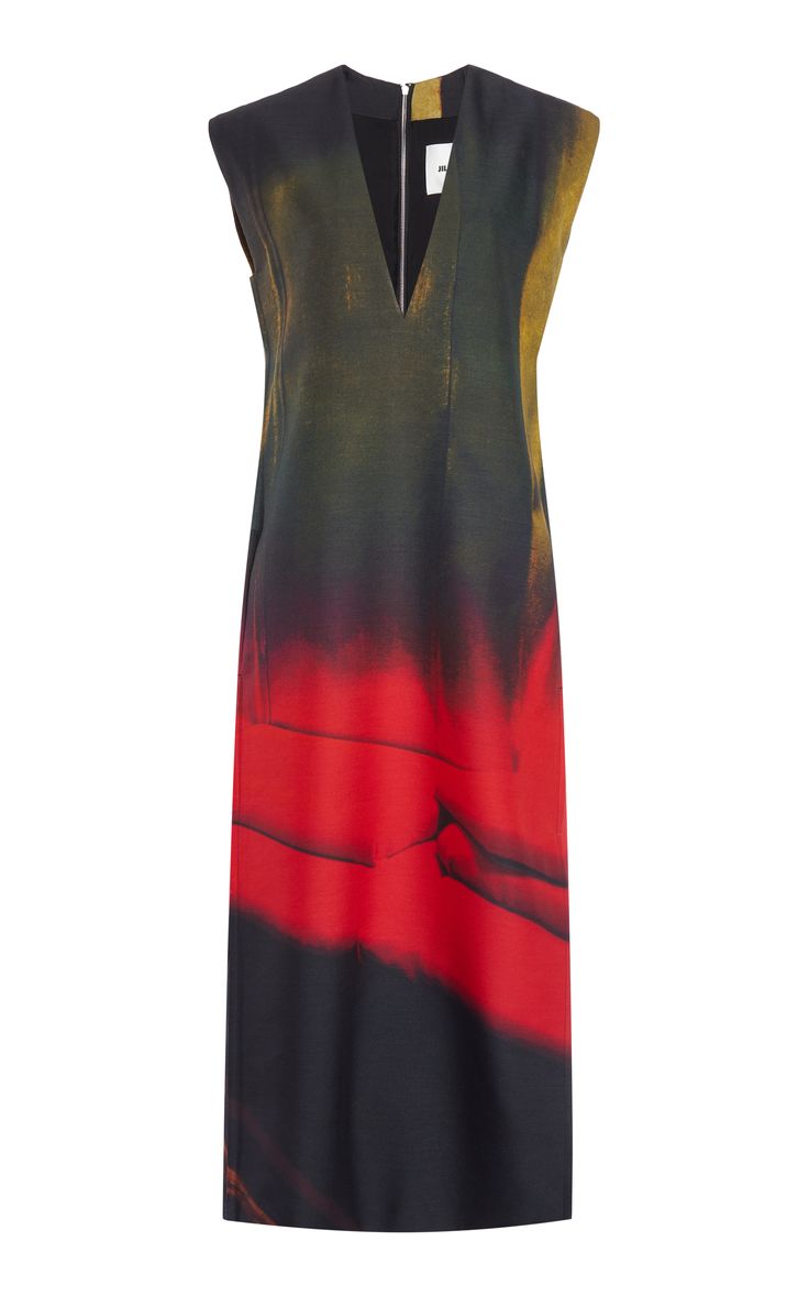 a sleeveless maxi dress with a vneckline and an abstract print in red, black, and yellow. the dress is flowy and casual, but also elegant. it would be perfect for a summer day out or a night out on the town.  the dress appears to be made of a light and flowy fabric. the neckline is cut low, and the straps are thin. the abstract print covers the entire dress.