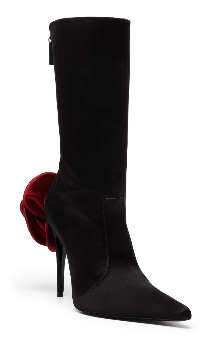 a pair of black satin kneehigh boots with a pointed toe and a red rose detail on the side. the boots have a high heel and a side zipper. they are elegant and stylish, perfect for a party or formal occasion.