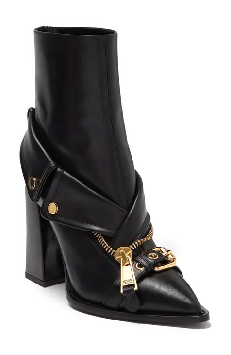 a black leather boot with a chunky heel and decorative gold zipper and buckles on the vamp.