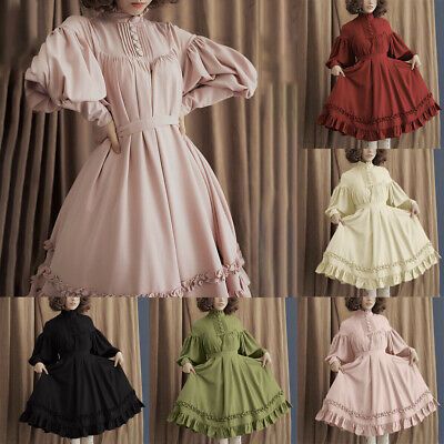 a woman models a series of six vintageinspired dresses against a neutral background. the dresses feature long sleeves, ruffles, and a high waist, and come in a variety of colors including pink, red, cream, green, black, and peach.