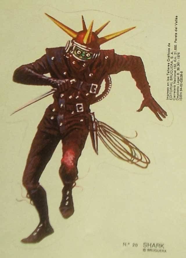 this is a sticker of a cartoon shark superhero/villain. it is wearing a black leather suit with a red and gold helmet with long pointy spikes. the character has a weapon that looks like a wire whip and a small sword. the background is yellow. the sticker is from the spanish publishing company bruguera.