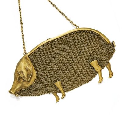 this image shows a goldcolored, mesh pig purse with a chain strap.  the purse has a chainlink pattern and a threedimensional pig head that protrudes from the body of the purse.