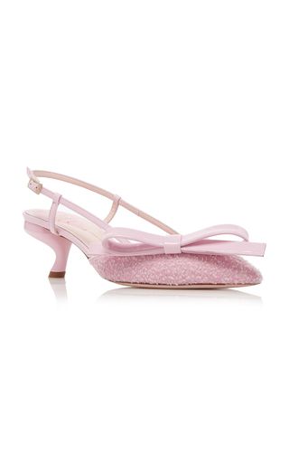 a pair of pink women's slingback heels with a bow on the front. the shoes have a kitten heel and are made of a soft, textured fabric. they are elegant and stylish, and would be perfect for a special occasion.
