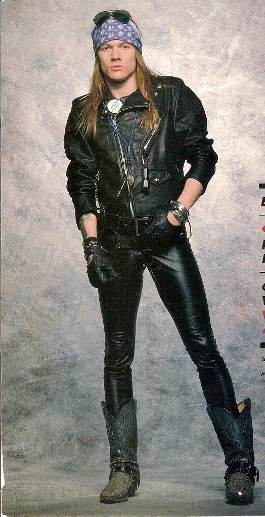 a fullbody studio shot of slash, the iconic guitarist of guns n' roses. he's dressed in his signature style: a black leather jacket, black leather pants, a bandana, sunglasses, and cowboy boots. he's wearing various pieces of jewelry and has his long hair down. the background is a textured grey. the image has a classic 80s/90s rock and roll aesthetic.