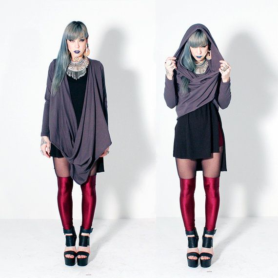 the image shows a woman dressed in two different variations of an outfit. on the left, she wears a black dress, metallic red leggings, black platform shoes, and a large grey shawl. she has grey hair, dark lipstick, and large jewelry. on the right, she wears the same dress, leggings, and shoes, but the shawl is worn as a hooded top. she is in front of a white background.