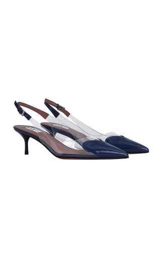 a pair of navy blue pointy toe slingback heels with transparent straps. the heels are high and the shoes are made of patent leather.