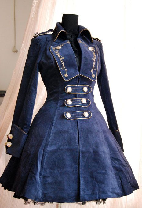 a blue corduroy dress with a militaryinspired design is displayed on a mannequin. the dress features gold trim, decorative buttons, a unique collar, long sleeves with buttoned cuffs, and a fitandflare silhouette. it has doublebreasted detailing with decorative buttons down the front, intricate embroidery around the collar, and a subtle lace trim at the bottom hem.