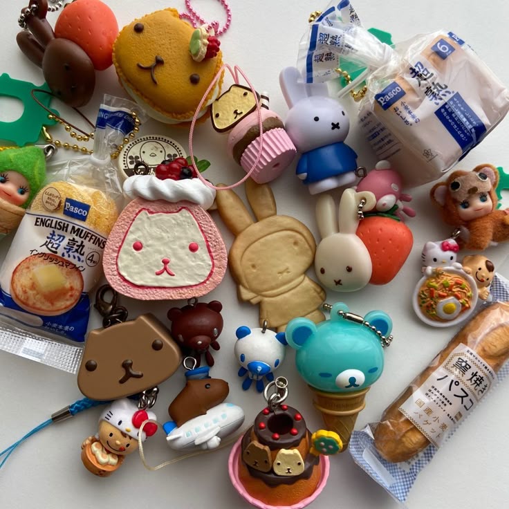 the image shows a collection of various kawaiistyle charms and keychains. there are several foodthemed charms like bread, muffins, strawberries, and desserts. there are also character charms featuring bunny, bear, and other animal designs. some of the charms appear to be based on japanese cartoon characters or brands.