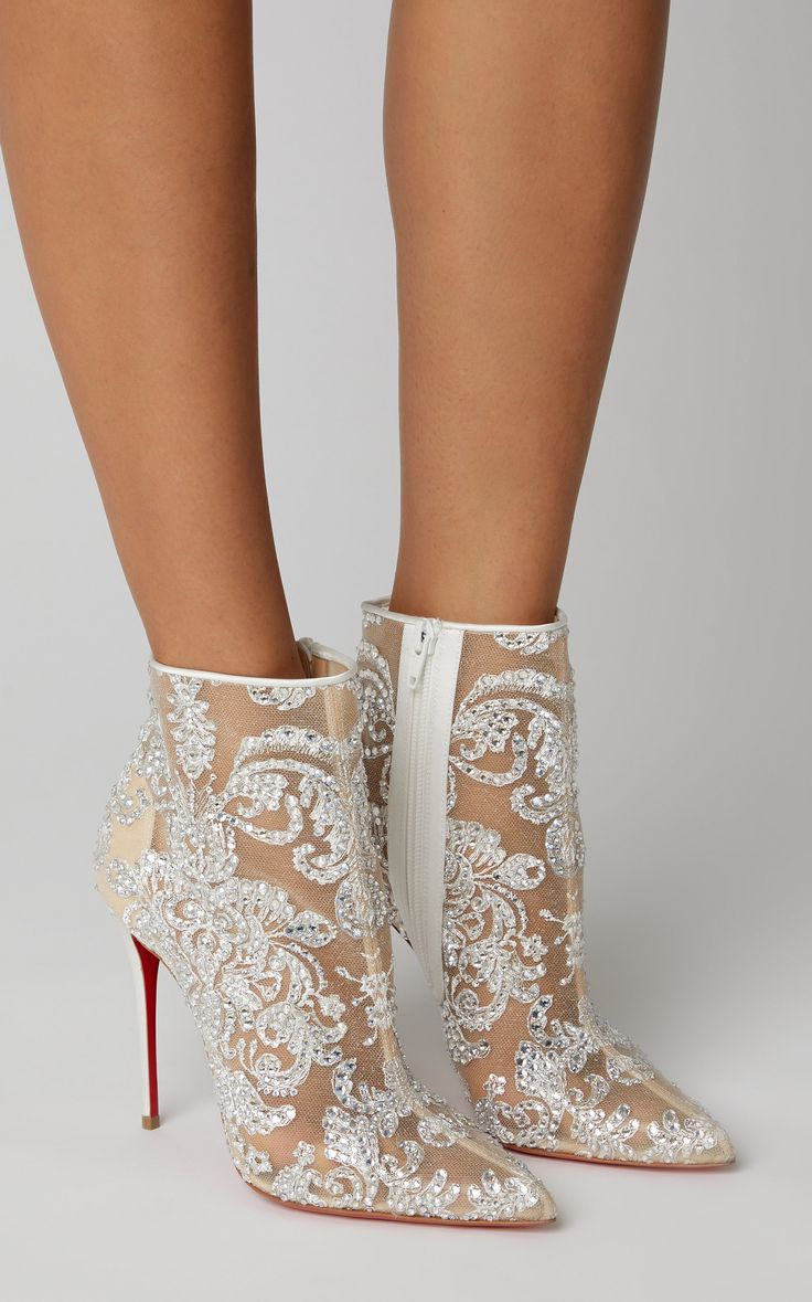 a woman is wearing a pair of white stiletto boots. the boots are covered in rhinestones and glitter. the woman is wearing a white dress. the boots are very stylish and elegant. the woman is standing on a white background.  the boots are bridal boots, that are perfect for a special occasion, such as a wedding.
