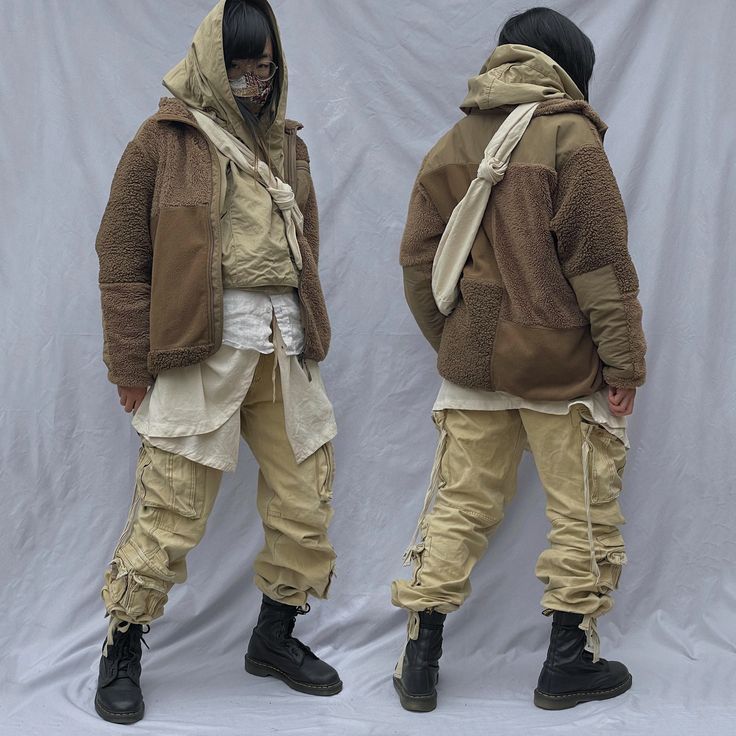 the image shows a fullbody shot of a person modeling a stylish outfit. the outfit consists of a brown and beige patchwork fleece hooded jacket, layered over a creamcolored top and a longer beige shirt, paired with loose beige cargo pants featuring drawstrings at the ankles. the model is also wearing black doc martens boots. the background is a plain, light gray fabric backdrop. the same outfit is shown from the front and back. the model wears a face covering. the overall style is a blend of streetwear, workwear, and vintage influences, characterized by neutral colors and layered textures.
