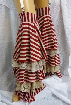 a closeup image showcasing a pair of red and white striped steampunk bloomers. these elaborate bloomers feature multiple tiers of ruffles and lace trim, adding a touch of vintage charm. the bloomers are held up by suspenders, further enhancing their steampunk aesthetic.