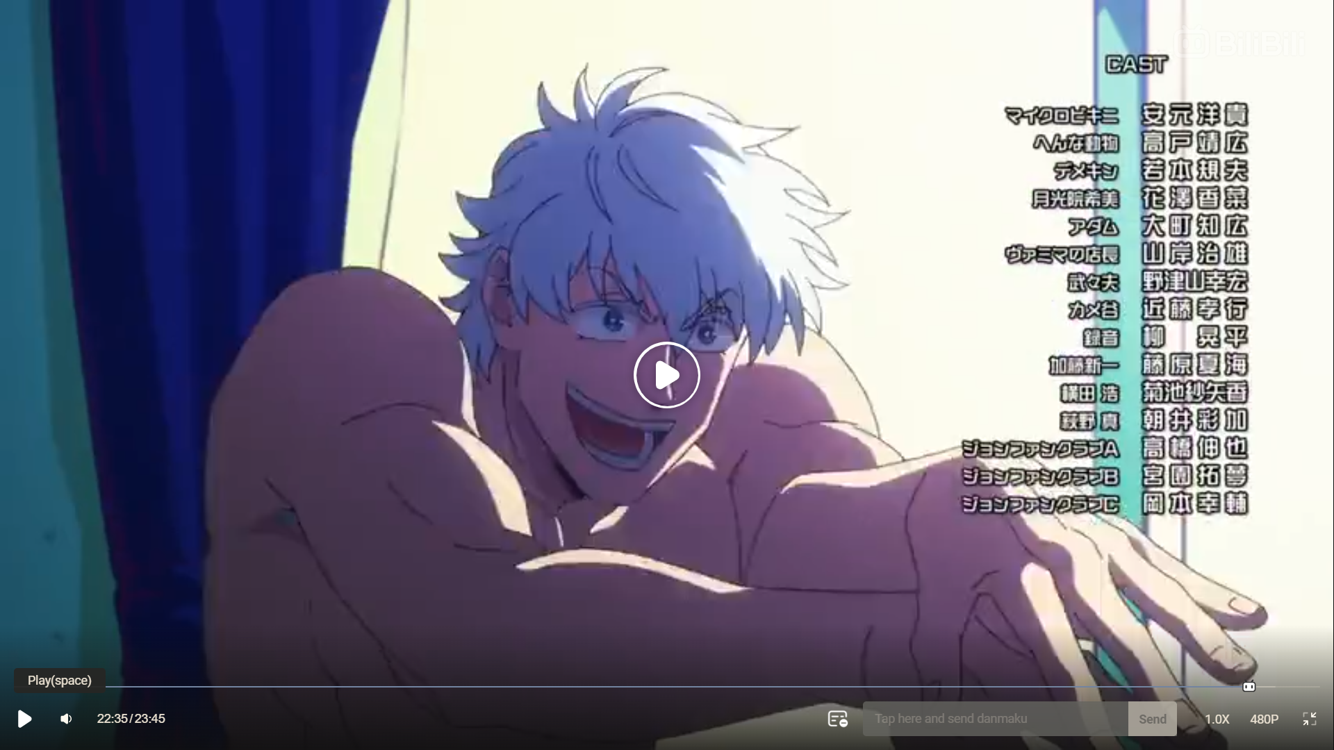 a screenshot from an anime showing a muscular, shirtless male character with white hair and a mischievous smirk. he is sitting up in bed, leaning forward with his hands outstretched towards the viewer. the background features a colorful bedroom setting with japanese text visible on the right side of the image, likely listing the voice actors for the anime. the image is brightly lit and uses a vibrant color palette.