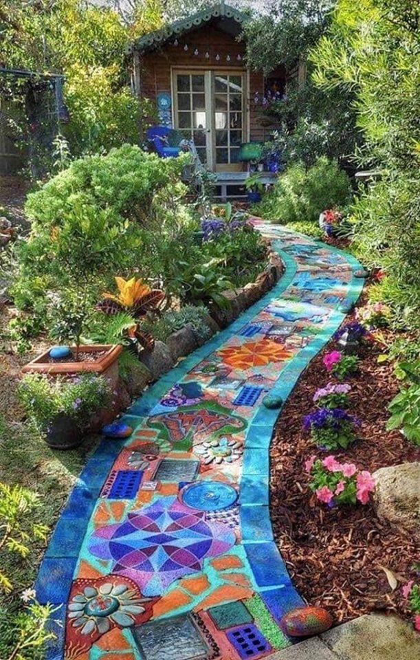 a whimsical garden scene features a mosaic pathway leading to a small wooden shed. the pathway is adorned with colorful tiles and patterns, creating a vibrant and artistic walkway. lush greenery and various flowers surround the pathway, adding to the garden's charm and beauty. the shed, nestled among the plants, adds a touch of rustic elegance to the scene.