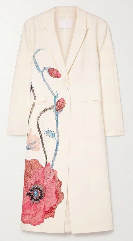 an ivory women's coat with an embroidered floral design is presented against a plain white background. the coat has a long, straight cut and features a single button closure near the top. the left side of the coat is adorned with an elaborate embroidered pattern of stylized poppies and stems in hues of pink, red, and blue. the collar is sharply tailored, giving the coat a formal appearance.