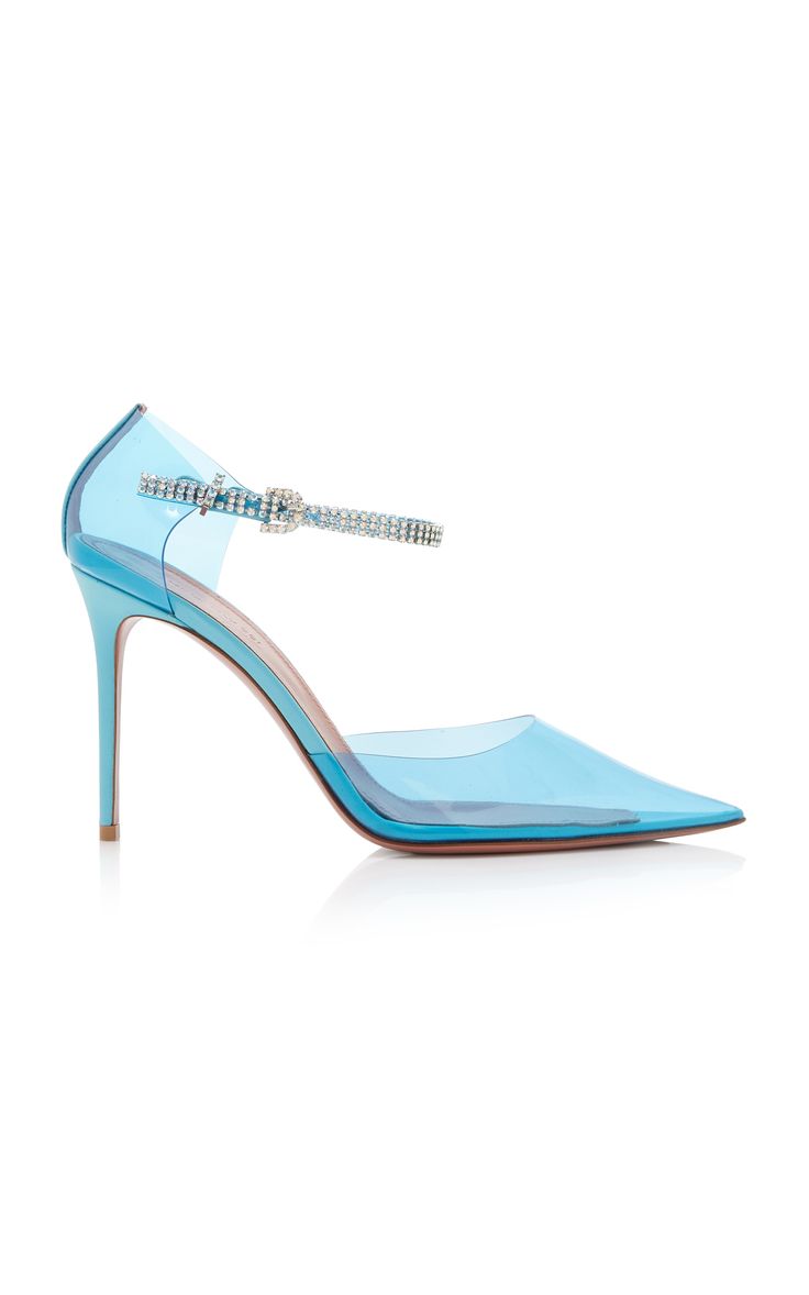 a pair of light blue transparent high heel pumps with a crystal embellished ankle strap are shown in the image. the shoes are pointedtoe stilettos with a thin heel.  they are positioned on a white background, angled slightly to show the side profile. the shoes appear to be made of a translucent plasticlike material, with the crystal embellishment adding a touch of sparkle.