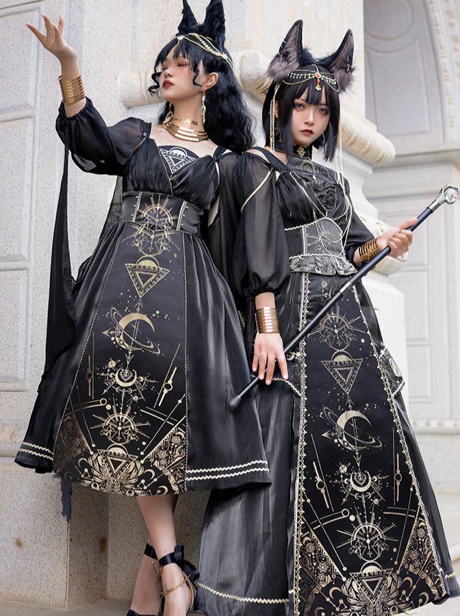 two women dressed in elaborate gothic lolita dresses stand sidebyside. they both wear black dresses with ornate gold patterns featuring celestial motifs. the woman on the left has a shorter dress and is raising her hand, while the woman on the right has a longer dress and is holding a cane. both women have cat ears and wear jewelry and accessories. they are standing outside, likely posing for a photo.