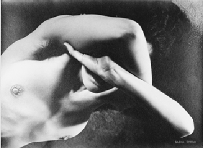 the image is a black and white, closeup photograph of a nude female torso. the subject's arms are wrapped around her chest, partially obscuring her breasts and face. the lighting is dramatic, with strong shadows contrasting against brightly lit areas of skin. the overall mood is sensual and introspective, with a sense of concealment and mystery. the photograph's style suggests it could be from the 20th century, possibly belonging to a fine art photography collection.  the image's focus is on the interplay of light and shadow across the body's curves and texture. a small circular object is visible near the left breast.