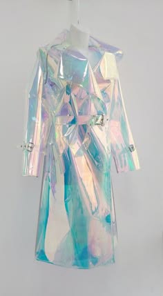 a beautiful iridescent raincoat that appears to have a rainbow color scheme with a white background hanging on a white hanger.  the raincoat has a simple design with a front closure and a belt, and the iridescent finish is very eyecatching.