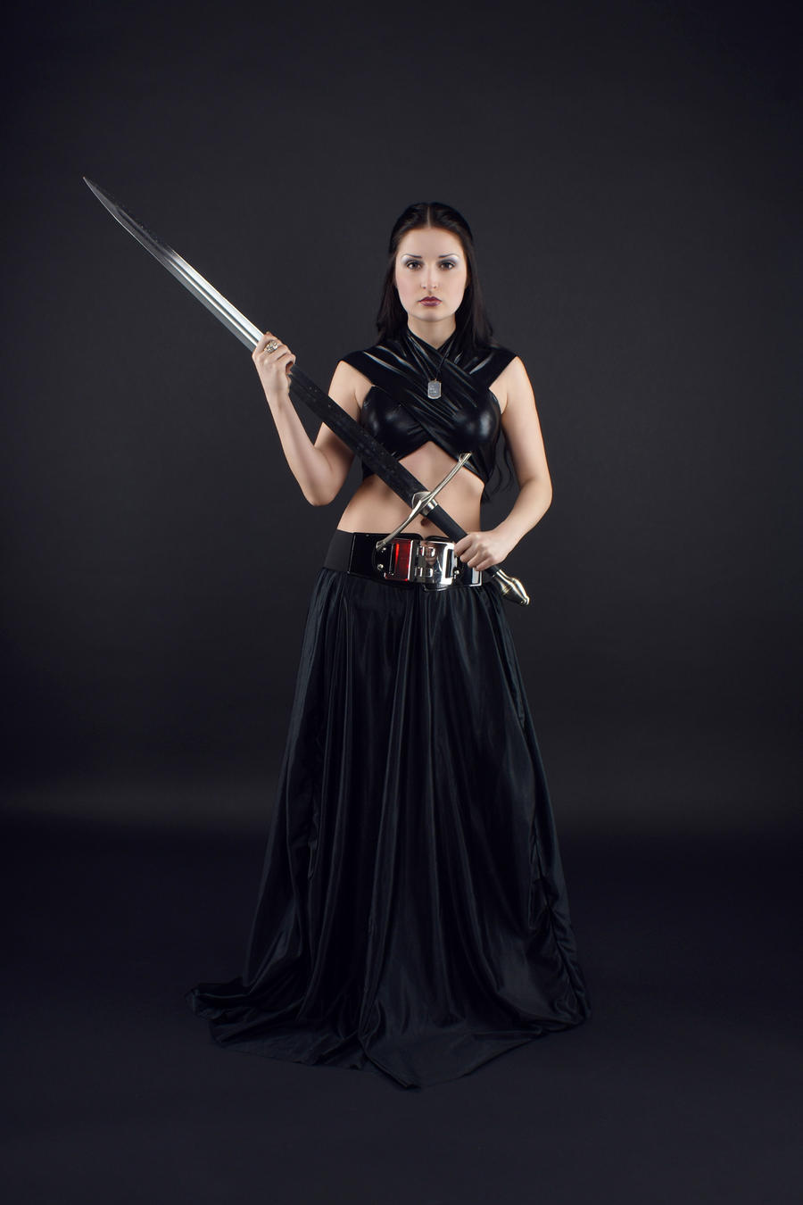 a fulllength shot of a woman dressed in a black fantasy warrior costume, standing against a black background. she is holding a sword across her body, looking directly at the camera with a serious expression. the overall mood is dark and mysterious, emphasizing the woman's power and confidence.