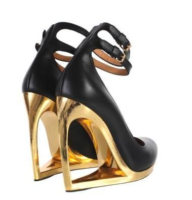 the image shows a pair of women's highheeled shoes.  the shoes are predominantly black leather with a striking gold platform and heel. the heel is uniquely designed with a geometric, almost architectural, cutout shape. the shoes feature ankle straps with buckles. they appear to be highend, designer shoes, showcasing a combination of sleek black leather and bold gold accents.  the angle of the photo shows both shoes in profile.