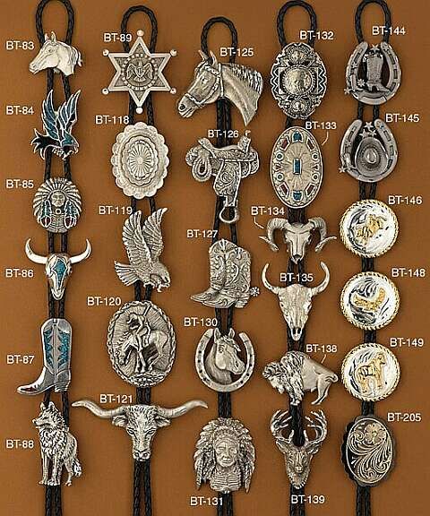 this image shows a collection of bolo ties, each featuring a different western or native american themed design. the bolo ties are displayed on a brown background, and each one is labeled with a product code.  the designs include horses, bulls, skulls, eagles, boots, horseshoes, stars, sheriff badges, saddles, rams, deer, wolves, birds, and more.  many incorporate turquoise accents. the image appears to be from a catalog or product listing.