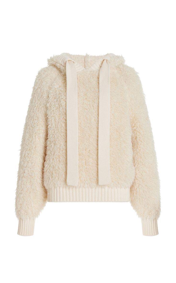 a cream colored fuzzy hooded sweater with long sleeves and drawstrings.