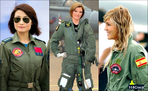 the image shows three women, all of whom are dressed in military flight suits. each woman is wearing a green jumpsuit with patches and insignia. the woman on the left is wearing sunglasses and has the flag of china on her suit. the woman in the center is smiling and has a badge on her suit. the woman on the right is also smiling and has the flag of spain on her suit. the background of the image is blurred and appears to be outdoors.