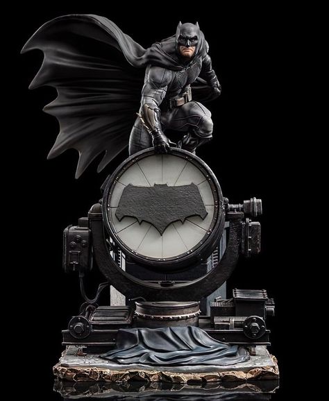 a black and white statue of batman, featuring a detailed sculpt of the character in his iconic cape and cowl. the statue is set on a base that includes a bat signal, a symbol that is often used to call batman to action. the statue is made of highquality materials and is a great addition to any batman fan's collection.