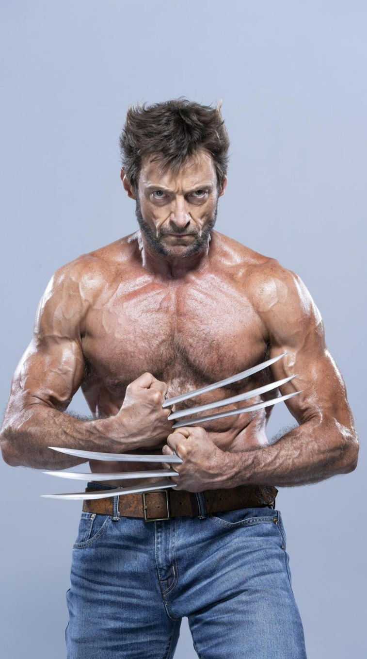 the image shows hugh jackman as wolverine, shirtless and muscular, with his claws extended. he is wearing blue jeans and a brown belt.