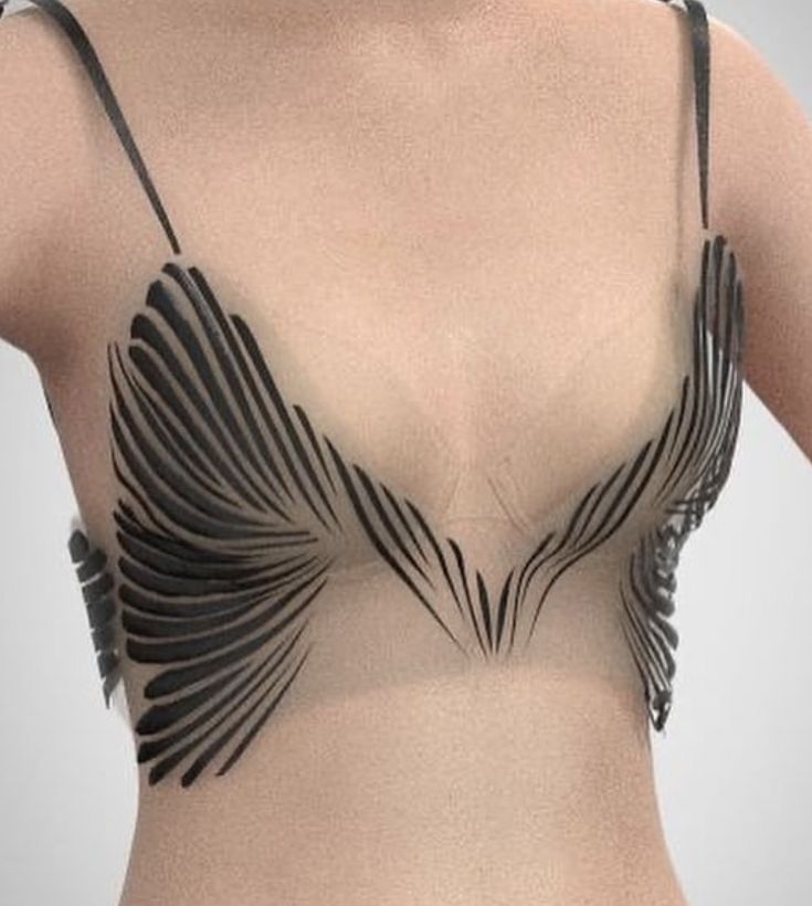 the image shows a woman's chest wearing a semitransparent bra with black strips radiating outwards, resembling wings. the bra has thin black straps.
