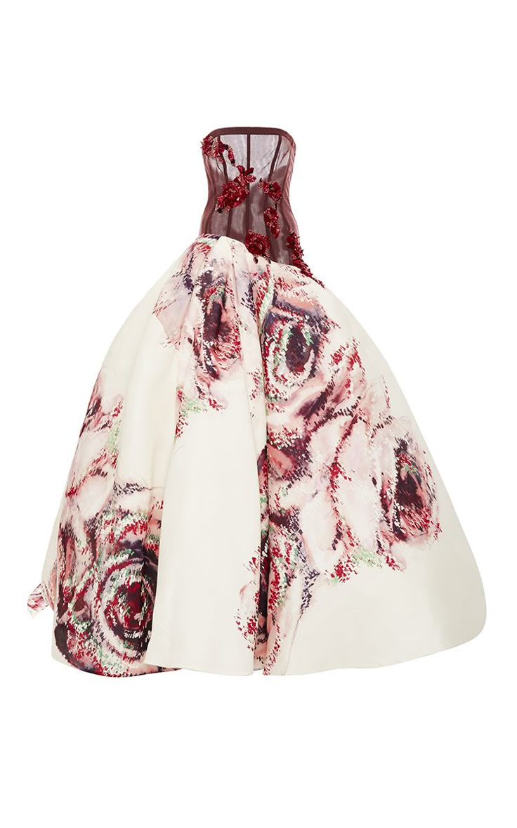a strapless burgundy and offwhite ball gown with a large floral pattern skirt is shown in a studio shot on a white background. the burgundy bodice has floral embellishments at the top. the skirt flares out dramatically and is covered with a large floral design in shades of burgundy, pink, and green.