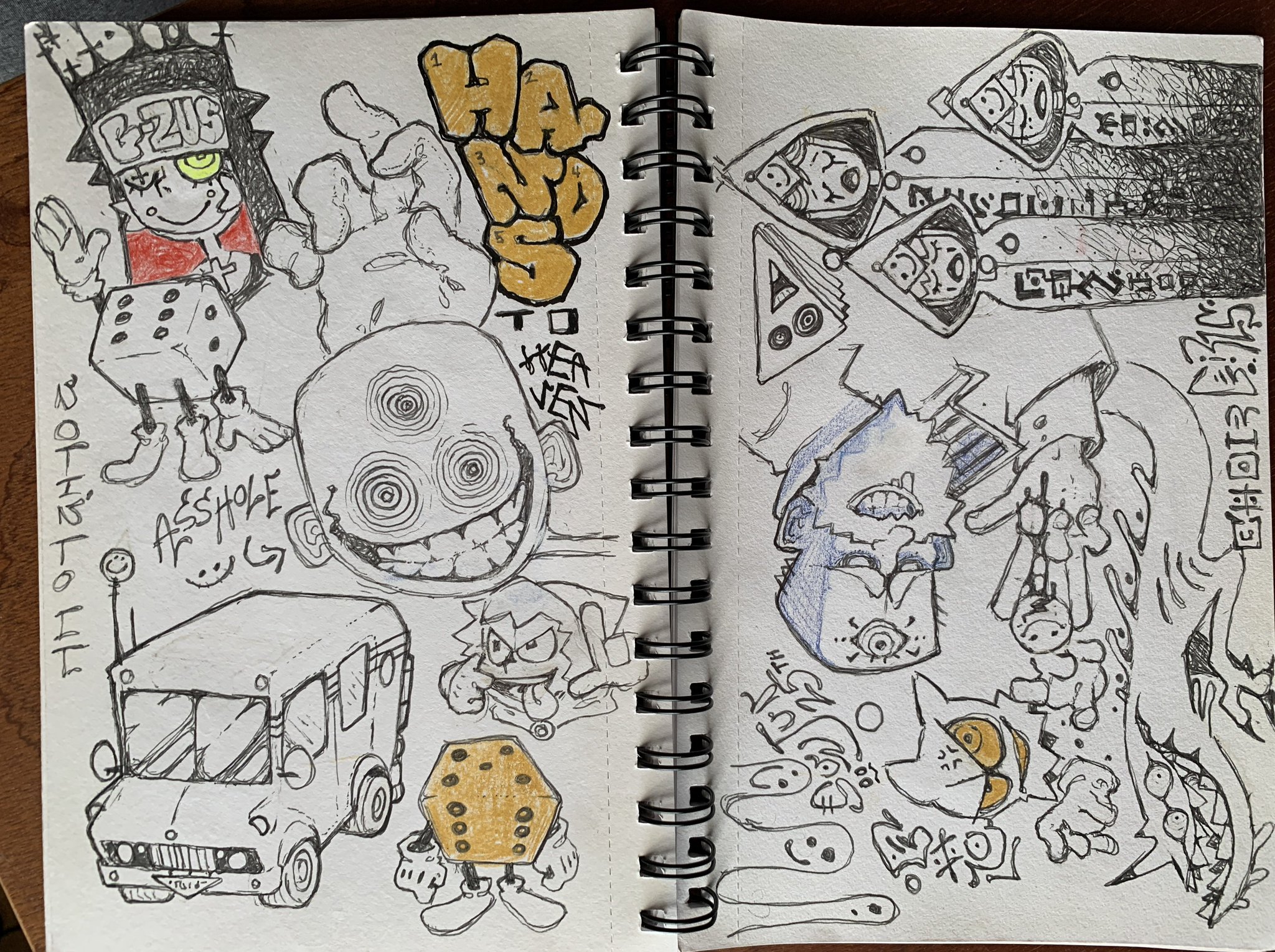 a notebook page is open with various cartoonish sketches. there's text on the page and various illustrations of creatures, some holding dice and some with multiple eyes.