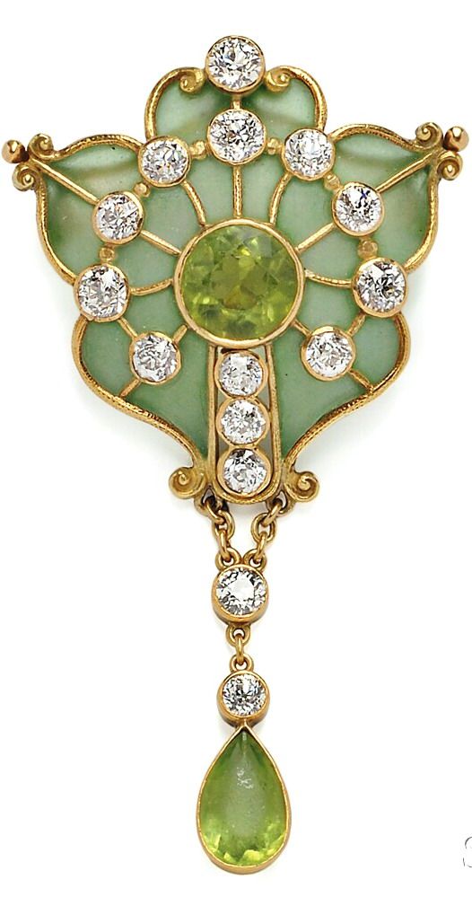 a detailed image of a gold pendant featuring a central green gemstone surrounded by a multitude of diamonds set in gold, with a pendant drop featuring a smaller green gem. the intricate goldwork design of the pendant is beautifully crafted and adds to its elegance.  the pendant is likely made of precious metal and gemstones, making it a highly valuable and prized piece of jewelry.