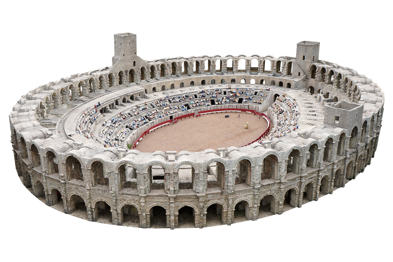 this is a highangle, medium shot of a miniature version of an old architectural structure, presumably an amphitheater or an arena. the structure is ovalshaped with multiple tiers of seating areas filled with miniature human figures, suggesting an event or performance taking place. the center area appears to be a dirt or sandcovered surface, surrounded by a red barrier. the building is constructed from stone or a similar material, featuring arched openings and tiered levels. the structure is set against a solid black background.