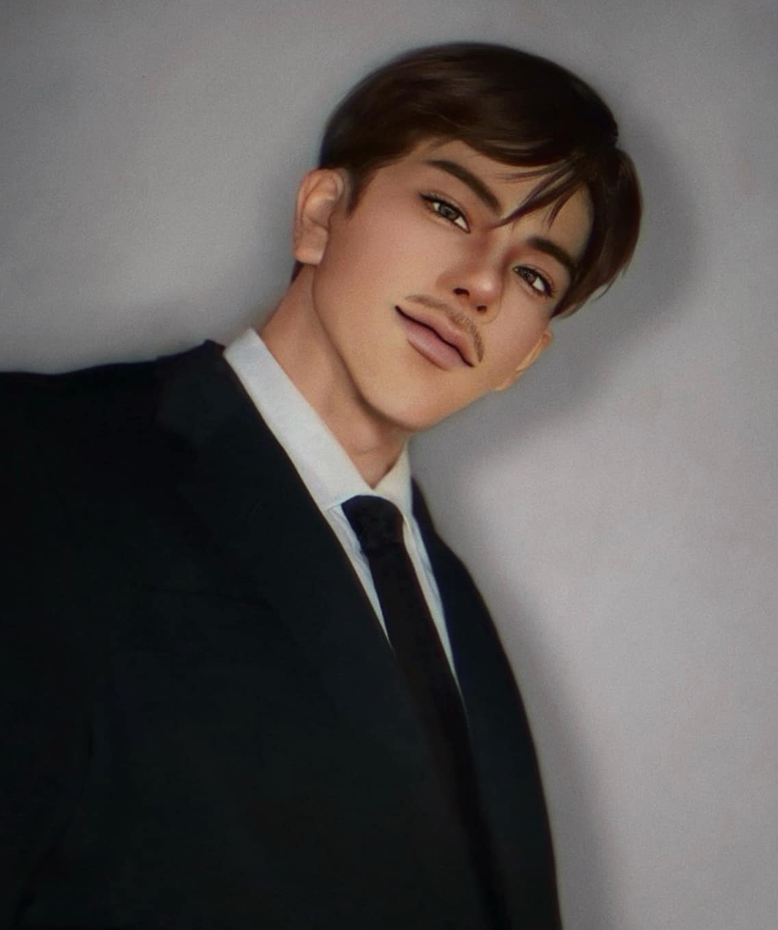 a young man in a black suit and tie smiles at the camera. he is standing in front of a gray background.