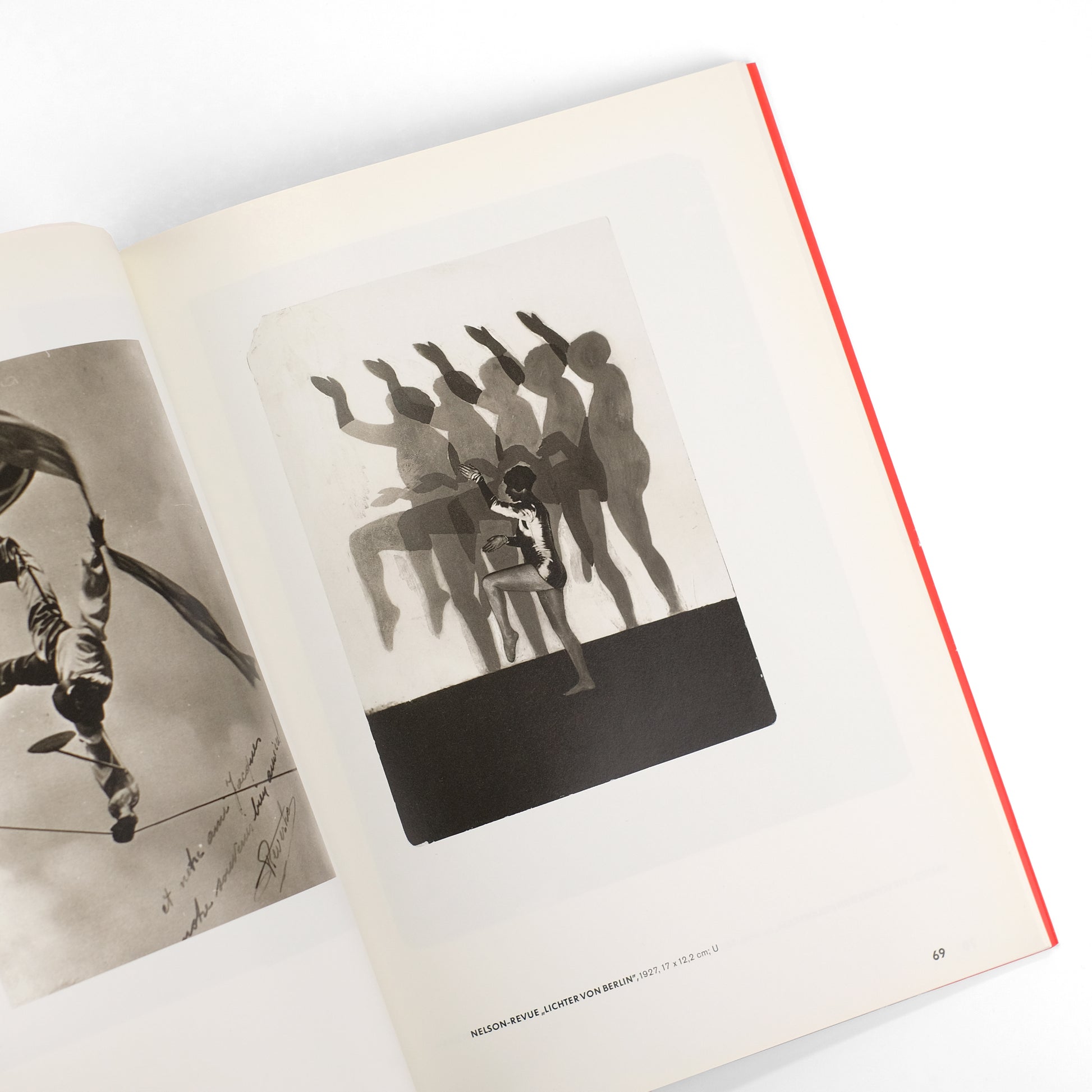 an image showing two open pages of a book. one page displays a black and white photograph of a gymnast performing a sequence of movements, depicted through overlapping silhouettes and motion blur. the other page shows a black and white photo of a performer on a trapeze. both photos seem to be vintage, possibly from the early to mid20th century. the book pages have a cream colored background and a bright red edge.  the bottom of the page featuring the gymnast image shows a caption indicating the source of the image: "nelson revue, lichter von berlin".
