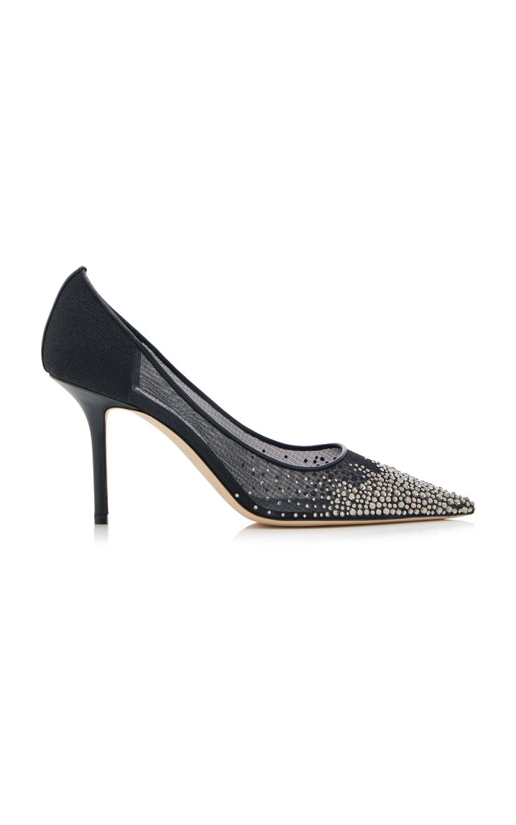 a pair of black mesh pumps with pointy toes and a stiletto heel, adorned with rhinestones all over.