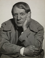 the image is a black and white closeup portrait photograph of pablo picasso. he appears to be middleaged or older, with his hair combed back. he's wearing a collared jacket or coat.  his expression is serious and thoughtful; he has one hand resting on his cheek. the background is a plain, lightcolored backdrop that keeps the focus entirely on picasso. the photograph has a timeless and classic quality.