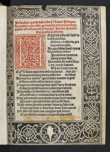 this image shows a page from a book, likely a manuscript. the page contains a decorative border surrounding the text in a gothic style. there is also a large, illuminated capital letter "e" at the beginning of the text. the letter is filled with decorative vines and foliage. the text is in latin and appears to be a poem or a dedication. the manuscript is likely from the renaissance period.
