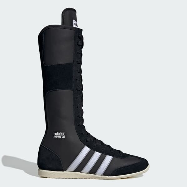 a pair of black adidas boxing boots with white stripes on the side and a white sole. the boots are laceup and have a vintage look. the words "adidas japan vh" are written on the side of the boots.