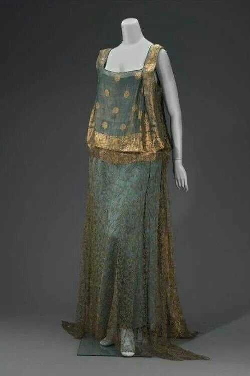 a floorlength sleeveless teal and gold dress is displayed on a mannequin. the dress features a square neckline, gold metallic accents, and a dot pattern.