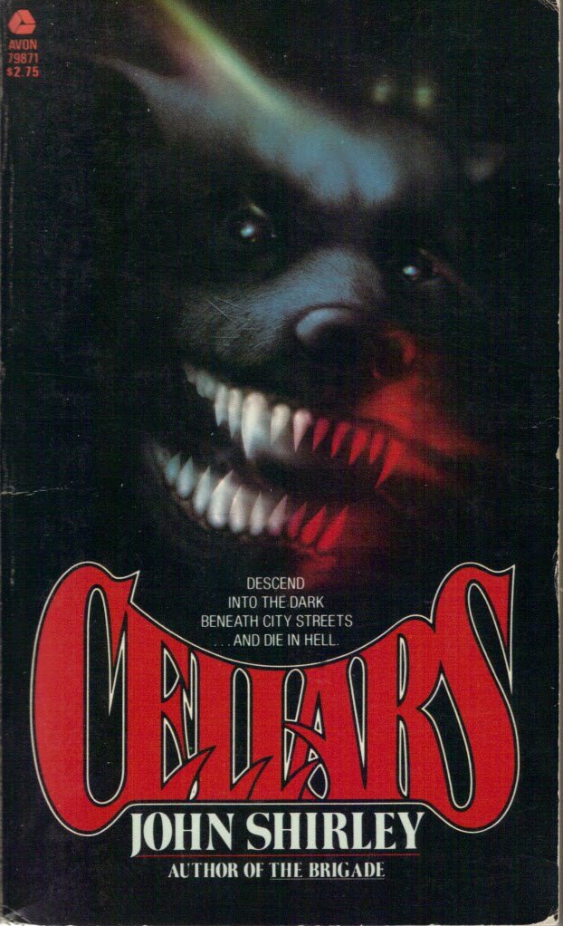 the image is a book cover for john shirley's cellars, published by avon books.  the cover art features a closeup of a monstrous dog's head, snarling and revealing sharp teeth. the background is dark, emphasizing the ominous and terrifying nature of the book's subject matter. the title "cellars" is prominently displayed in large, stylized red lettering.  the tagline, "descend into the dark beneath city streets... and die in hell," adds to the book's suspenseful and frightening atmosphere.  the author's name and previous work ("author of the brigade") are also visible at the bottom.  the avon books logo and publication number are in the upperleft corner, along with the price.  the overall style is consistent with 1980s horror and science fiction paperback cover art.