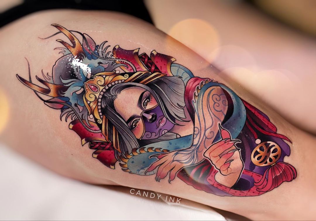 a neotraditional tattoo of a woman warrior with an oni mask on her face. there are colorful dragons around the woman and she is wearing an elaborate headdress. the tattoo is done in bright colors and has a lot of detail.